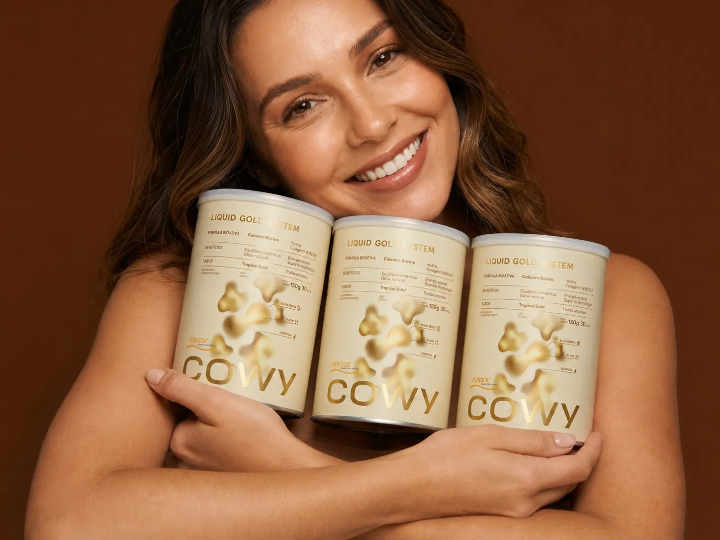 Mulher sorrindo abraçando potes de COWY Ouro Líquido