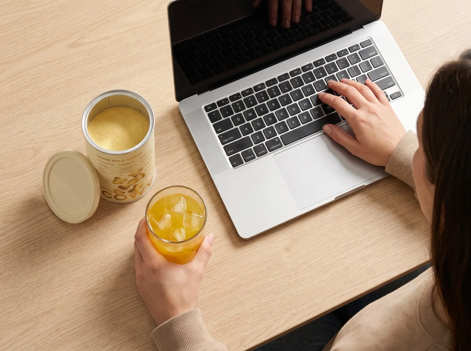 Bebida COWY ao lado do notebook no trabalho